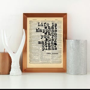 Stampa con citazione di John Lennon "La vita è ciò che ti accade mentre sei impegnato a fare altri progetti." su carta da dizionario vintage – Wall Art Life, testo della canzone