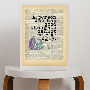 May include: A framed print on a vintage dictionary page featuring the quote A person who has good thoughts cannot ever be ugly by Roald Dahl from The Twits, with a colourful illustration of two characters in purple and green clothing.