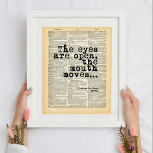 May include: A framed print featuring a vintage dictionary page with the black typewriter-style text: The eyes are open, the mouth moves... Blackadder Goes Forth. The print is set within a simple white frame against a plain white background.