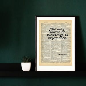 Könnte beinhalten: Ein gerahmter Druck mit einem Hintergrund aus einer alten Wörterbuchseite mit dem schwarzen Text, The only source of knowledge is experience, und dem Namen Albert Einstein, der unter dem Zitat in einer klaren, fetten serifenlosen Schrift gedruckt ist.
