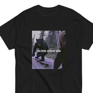 May include: Black t-shirt featuring a graphic of a bear skateboarding with the text "become unbearable".