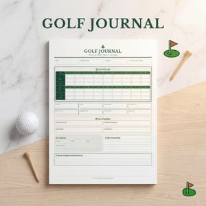 May include: A white golf journal with the text "GOLF JOURNAL" at the top. The journal includes a scorecard, round highlights, and areas to improve. A golf ball and tee are next to the journal.
