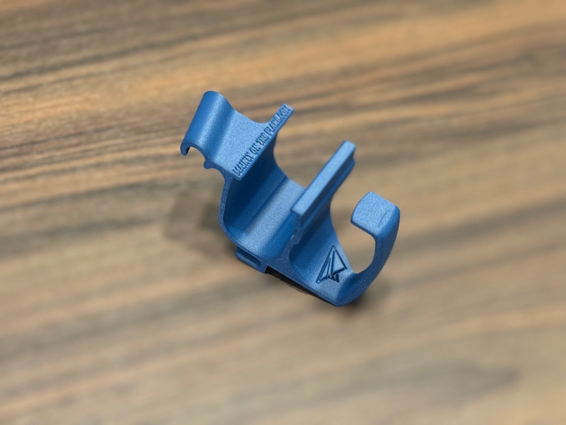May include: A blue plastic phone holder with a small paper airplane logo and the text "Made of You" printed on it.