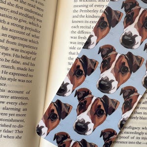 Personalised pet bookmark placed inside open book, custom dog or cat portrait reading accessory thoughtful gift for bookworms.