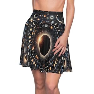 Op de afbeelding: Een skaterrok met hoge taille en een zwarte achtergrond met een hemelse print van verschillende maanfasen, gloeiende sterren en planeten. Het patroon straalt uit vanaf een centraal donker eclips-motief met gouden lichtstralen tegen een sterrenhemel.