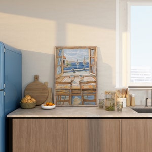 May include: A framed painting of a window overlooking a seascape with sailboats. The window is open and there are two chairs and a table with two mugs on it. The painting is in a kitchen setting with a blue refrigerator, wooden cabinets, and a window with a view of a city.