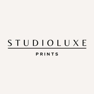 May include: Black and white logo for Studioluxe Prints. The logo features the text "Studioluxe" in a bold, sans-serif font with a thin line underneath. The text "Prints" is below the line in a smaller font.