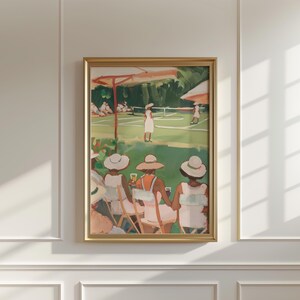 May include: A painting of a tennis match with people watching from the sidelines. The painting is in a gold frame and features a green tennis court, a group of people in white clothing playing tennis, and a group of people in white dresses and hats watching the game.