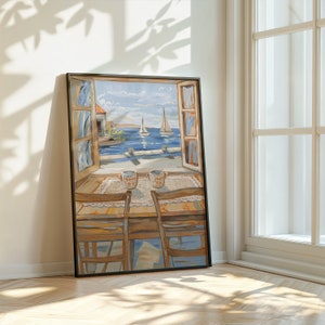 May include: A framed painting of a window overlooking a seascape with two sailboats in the distance. The window is open and there are two mugs on a table in front of it. The table is made of wood and has a white tablecloth. The mugs are white with a red and blue design.