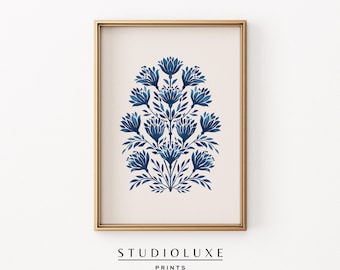 May include: A framed art print featuring a stylized floral design in shades of blue. The artwork is set against a neutral background and framed in a gold-colored frame. The text "STUDIOLUXE PRINTS" is printed at the bottom.