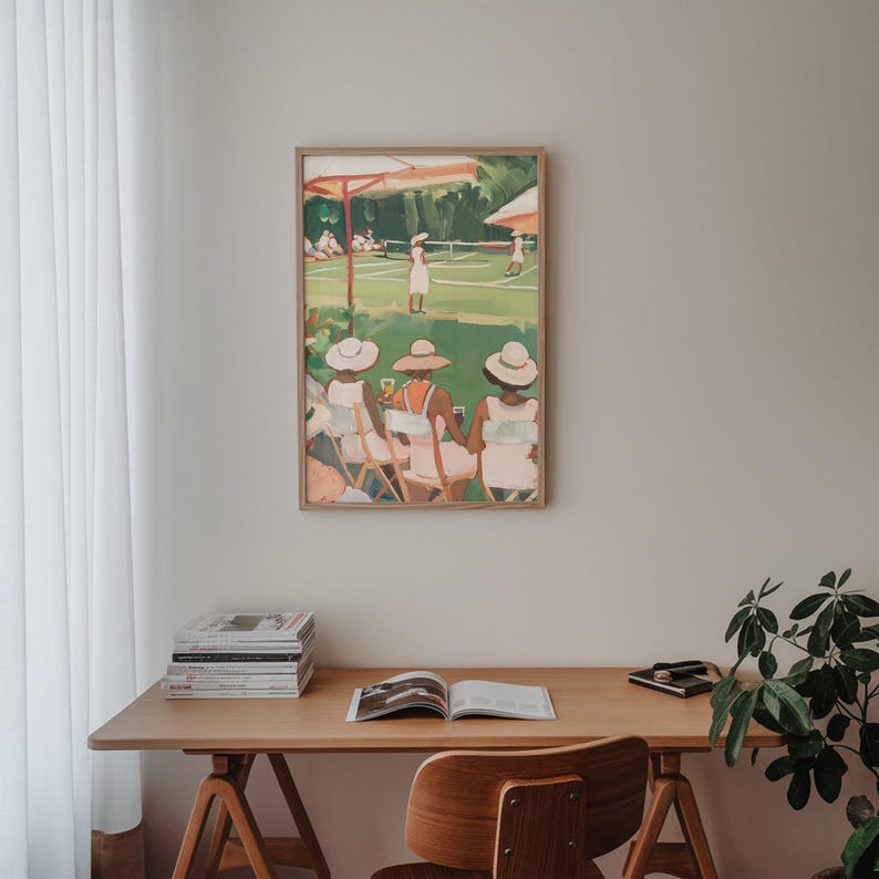May include: A framed painting of three women wearing hats and sitting on chairs, watching a tennis match on a green court. The painting is in a light wood frame and is hanging on a white wall.