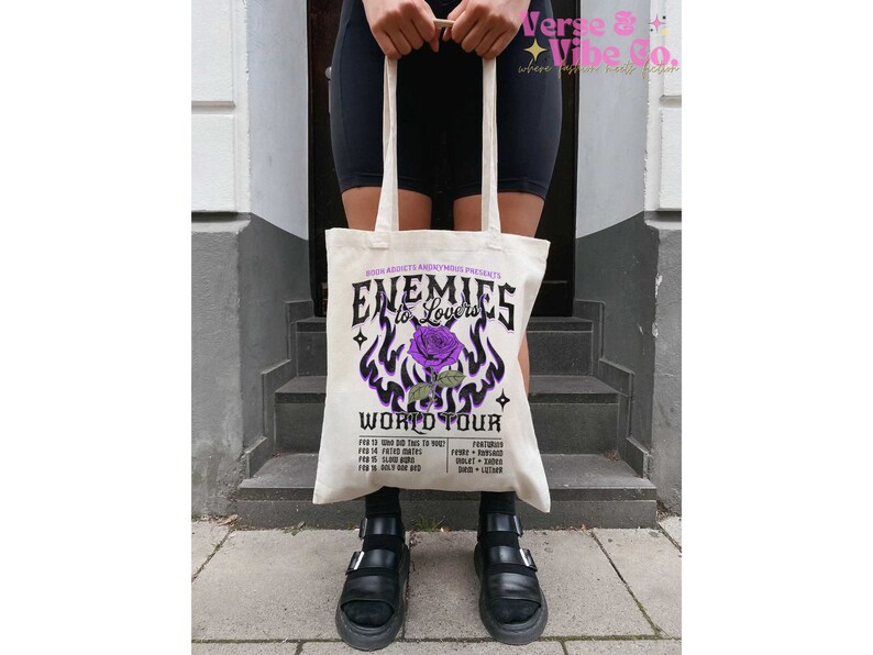 May include: A white tote bag with a purple and black graphic design featuring a rose and the text "Enemies to Lovers World Tour".