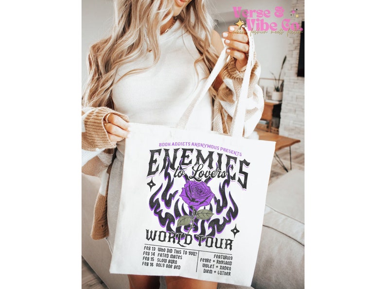 May include: White canvas tote bag with a purple and black graphic design that says "Enemies to Lovers World Tour". The graphic features a purple rose with flames and stars.