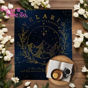 K&ouml;nnte beinhalten: Eine blaue und goldene Decke mit einem himmlischen Design. Das Design zeigt einen Kreis mit Sternen, Bergen und einem belaubten Zweig. Der Text "VELARIS - CITY OF STARLIGHT" ist in goldenen Buchstaben geschrieben. Der Text "To the stars and the dreams the" ist in goldenen Buchstaben am unteren Rand der Decke geschrieben.