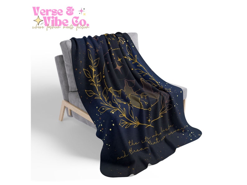 K&ouml;nnte beinhalten: Eine marineblaue Kuscheldecke mit einem goldenen Sternbild-Design und dem Text "the stars above the city that never sleeps and dream that is alive".
