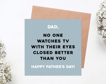 May include: A Father's Day card with a pale blue background and a brown envelope. The card reads "DAD, NO ONE WATCHES TV WITH THEIR EYES CLOSED BETTER THAN YOU HAPPY FATHER'S DAY!" in black and white text. White flowers are in the background.