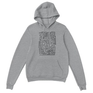 Könnte beinhalten: Ein grauer Kapuzenpullover mit einem schwarzen abstrakten Design auf der Vorderseite. Das Design besteht aus einer Reihe von Linien und Formen, die ein geometrisches Muster bilden.
