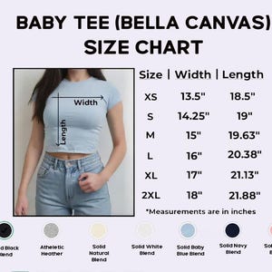 May include: Baby tee size chart with measurements in inches. The chart includes sizes XS to 2XL, with width and length measurements. A model is wearing a light blue baby tee. Color options include solid black, heather, natural, white, baby blue, navy, and pink.