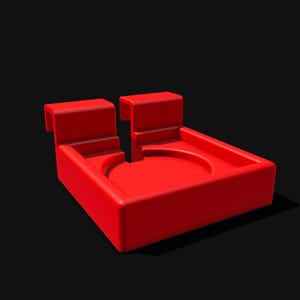May include: A bright red, geometric object with a rectangular base and two upright, rectangular extensions. The center features a circular indentation. The object is set against a black background, casting a shadow.