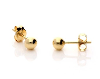 Può includere: Un paio di orecchini a lobo in oro con forma di sfera. Gli orecchini sono piccoli e semplici, con una forma rotonda e liscia.