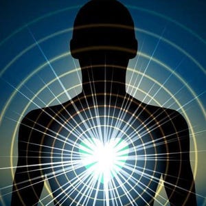 Puede incluir: Una silueta de una persona con un corazón brillante y luminoso en el centro de su pecho. El corazón está rodeado de luz radiante y un patrón de cuadrícula.