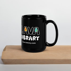 May include: Black ceramic mug with a white design that says "Lava Library" with a website address below. The design features a stylized "L" with a red and yellow lava flow, a stylized "A" with a blue and green earth, and a stylized "V" with a yellow and orange sun.