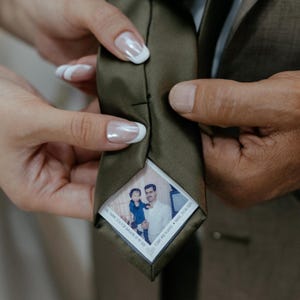 Könnte beinhalten: Eine grüne Krawatte mit einem Foto von Vater und Sohn. Das Foto ist in einem weißen Rahmen mit dem Text "TOUCH AND SHARE MY STORY" und "THANK YOU FOR ANSWERING MY SOS".