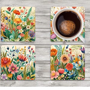 May include: Four square coasters with a floral design. The coasters feature a variety of colorful flowers, including orange, pink, and blue blooms, with green foliage. One coaster holds a white mug filled with dark coffee.