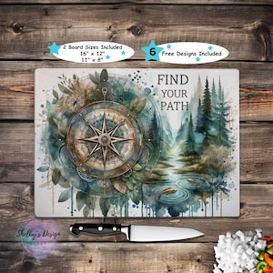 May include: A rectangular cutting board with a compass and forest design, the text "FIND YOUR PATH". Includes two board sizes: 16" x 12" and 11" x 8". A black-handled knife is placed below the board.