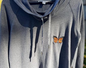 Sudadera gris con cuello alto y mariposa monarca bordada, talla grande - Reciclada