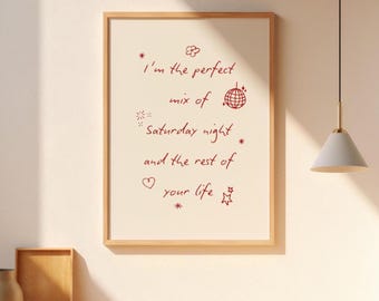 Puede incluir: Un cuadro enmarcado con el texto "I'm the perfect mix of Saturday night and the rest of your life" en escritura roja. El cuadro tiene un fondo beige claro y un marco de madera. Elementos decorativos: bola de discoteca, estrellas y un corazón.