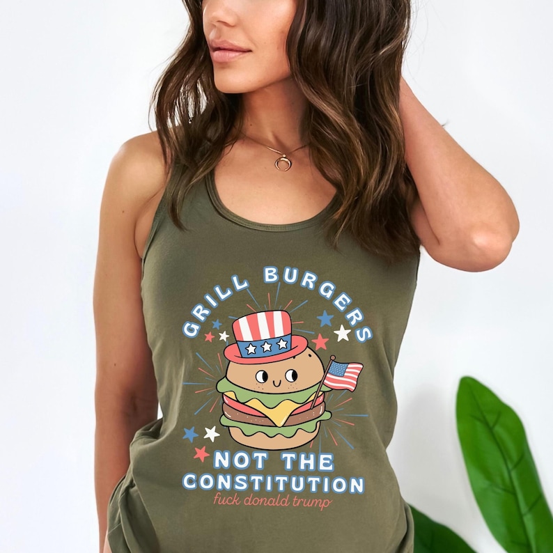 May include: Olive green tank top featuring a burger wearing a patriotic hat and holding a small American flag. The text reads "GRILL BURGERS" and "NOT THE CONSTITUTION fuck donald trump".