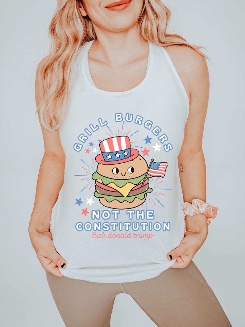 May include: White vest top featuring a cartoon burger wearing a patriotic hat and holding an American flag. The text reads "GRILL BURGERS NOT THE CONSTITUTION fuck donald trump" in blue and red.