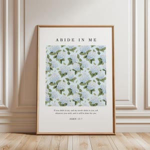 Puede incluir: Un póster de arte de pared imprimible con un diseño floral de hortensias azules sobre un fondo azul claro. El texto "ABIDE IN ME" está en la parte superior del póster. El texto "Si permanecéis en mí, y mis palabras permanecen en vosotros, pedid todo lo que queráis, y os será concedido." está en la esquina inferior izquierda. El texto "JUAN 15:7" está en el centro inferior.