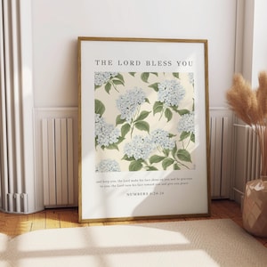 May include: A framed print featuring a floral design of white hydrangeas on a cream background. The print includes the text "The Lord Bless You" and a Bible verse from Numbers 6:24-26.
