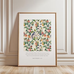 May include: Framed art print featuring a detailed botanical pattern of apples, berries, and birds on a cream background. The print includes the text "Look at the birds of the air... Matthew 6:26" in a simple, elegant font. The frame is a warm, natural wood tone.