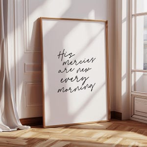 May include: A white framed print with black calligraphy that reads "His mercies are new every morning".