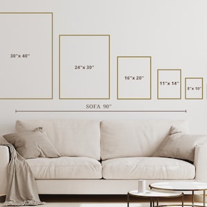 May include: A white sofa with a brown throw blanket, a white coffee table, and a smaller white side table. The wall behind the sofa has five gold frames with different sizes and dimensions, including 30" x 40", 24" x 30", 16" x 20", 11" x 14", 8" x 10", and 5" x 7". The sofa is 90" wide.