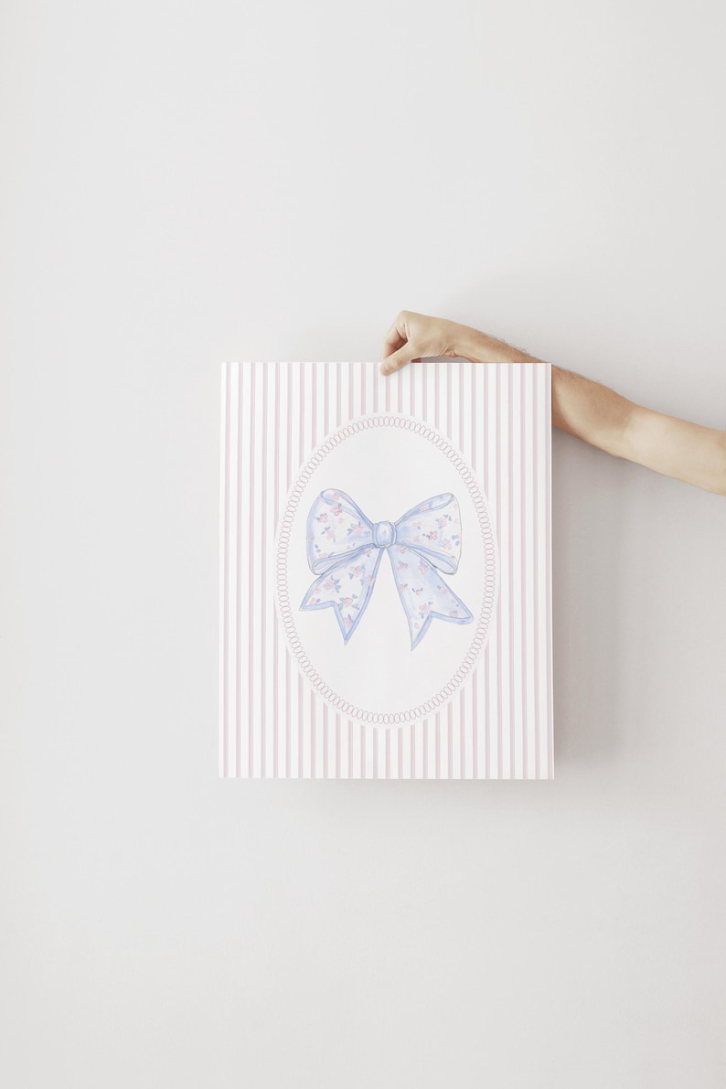 May include: A watercolor print of a blue bow with a floral pattern on a pink and white striped background.