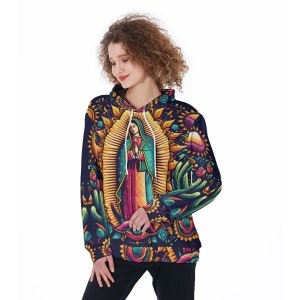 May include: A navy blue hoodie featuring a vibrant illustration of the Virgin of Guadalupe. The design includes a halo, floral elements, and a colorful depiction of the religious figure. The hoodie has a drawstring hood and long sleeves.
