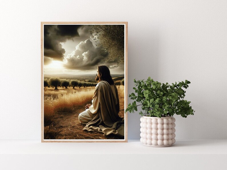 May include: A framed print of a man in a robe sitting in a field with his head bowed in prayer. The sky is cloudy and the sun is setting in the distance.