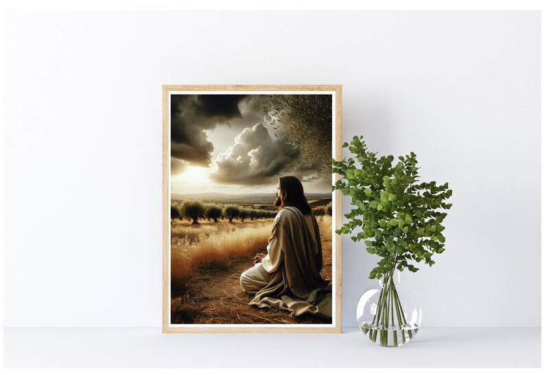 May include: A framed print of a man in a white robe kneeling in a field with a cloudy sky and a sunset in the background.