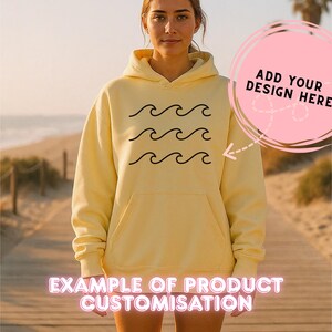 May include: A light yellow hoodie with a black wave design. The hoodie has a front pocket and a hood. Text on the image says "ADD YOUR DESIGN HERE" and "EXAMPLE OF PRODUCT CUSTOMISATION".