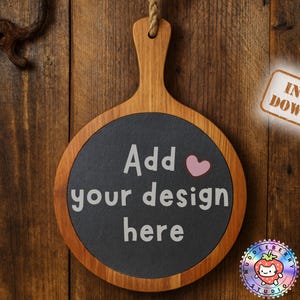 May include: A round wooden serving board with a dark gray center, featuring the text "Add your design here" and a pink heart. The board hangs from a rope against a wooden background. A sticker reads "Instant Download".