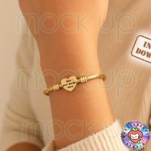 May include: Gold-colored bangle bracelet with a heart-shaped charm. The charm has the text "Add your design here". The bracelet has a twisted rope design. The image also includes the text "Instant Download".