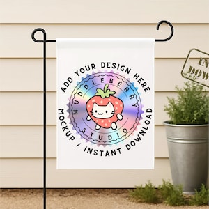 May include: A white garden flag on a black metal stand. The flag displays a colourful strawberry cat design with the text "ADD YOUR DESIGN HERE" and "MOCKUP / INSTANT DOWNLOAD". A small plant in a metal pot is in the background.