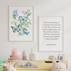 May include: A light blue framed print with a watercolour painting of butterflies on a branch. A second white framed print with a bible verse from Psalm 103:17-18. A light blue chair with a yellow cushion. A wooden shelf with a pink balloon that says "HAPPY", a wooden toy, a white bunny figurine, a grey cloud figurine, and a brown teddy bear.