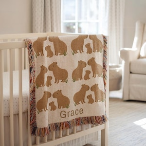 Custom Capybara Name Blanket – Personalized Woven Baby Blanket for Nursery Decor and Gifts
Celebrate a new arrival with this adorable personalized capybara baby blanket. Made with heirloom-quality woven fabric, this cozy blanket features a sweet capybara design and your chosen name, making it a perfect keepsake. Ideal for baby showers, first birthdays, or Christmas gifts, it’s a charming addition to any capybara-themed nursery or animal-lover’s room. A thoughtful gift for toddlers and kids.