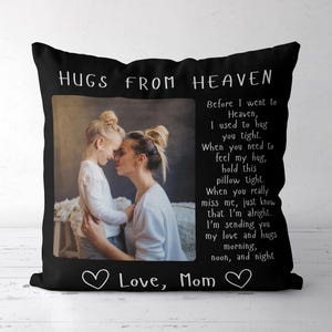 May include: A black square throw pillow featuring a photograph of a child and an adult embracing. The text reads HUGS FROM HEAVEN, a poem about missing loved ones, and Love, Mom, with two white heart outlines at the bottom.