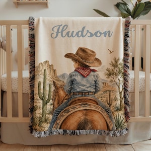 Western cowboy baby blanket personalized with baby name details, cowboy nursery artwork, and rodeo horse inspired style for a baby boy blanket or cowboy baby shower gift. This custom baby blanket is perfect for western baby gift ideas, toddler boy gifts, blanket for kids décor, and baby keepsake displays. A unique baby boy gift for families who love horseback riding, first rodeo themes, Southwest nursery style, and cowboy baby blankets.